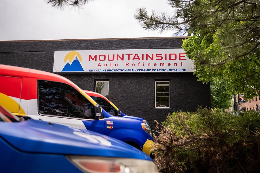 Parked red and blue vans in front of a Mountainside professional building sign