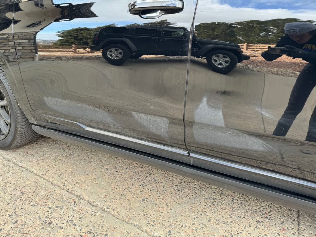 A black truck is parked on the side of the road.