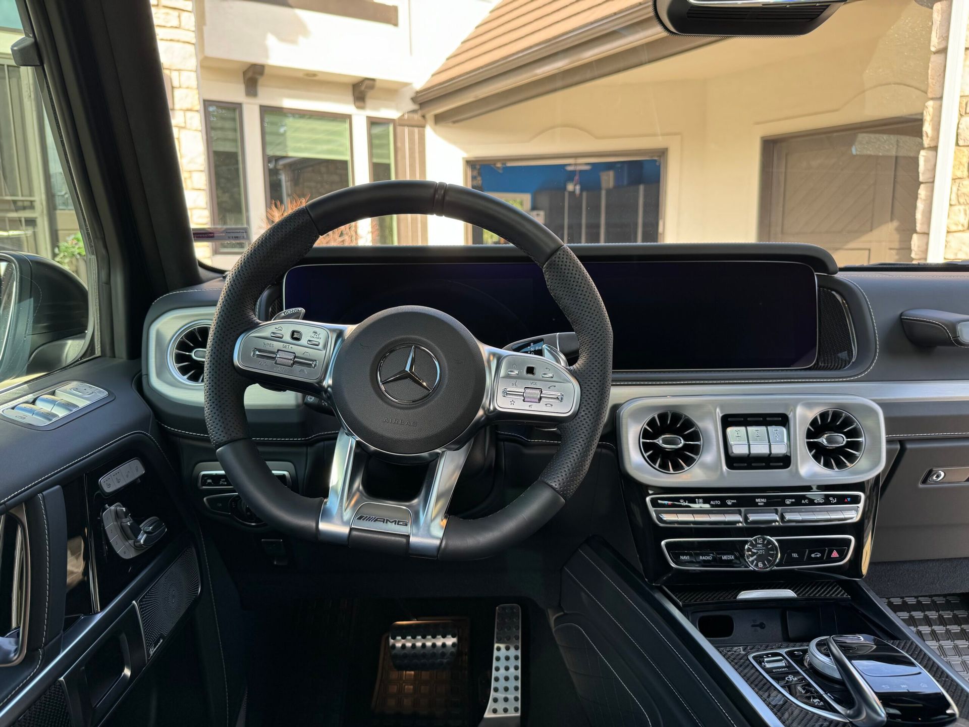 The interior of a mercedes benz g63 amg with a steering wheel and dashboard.