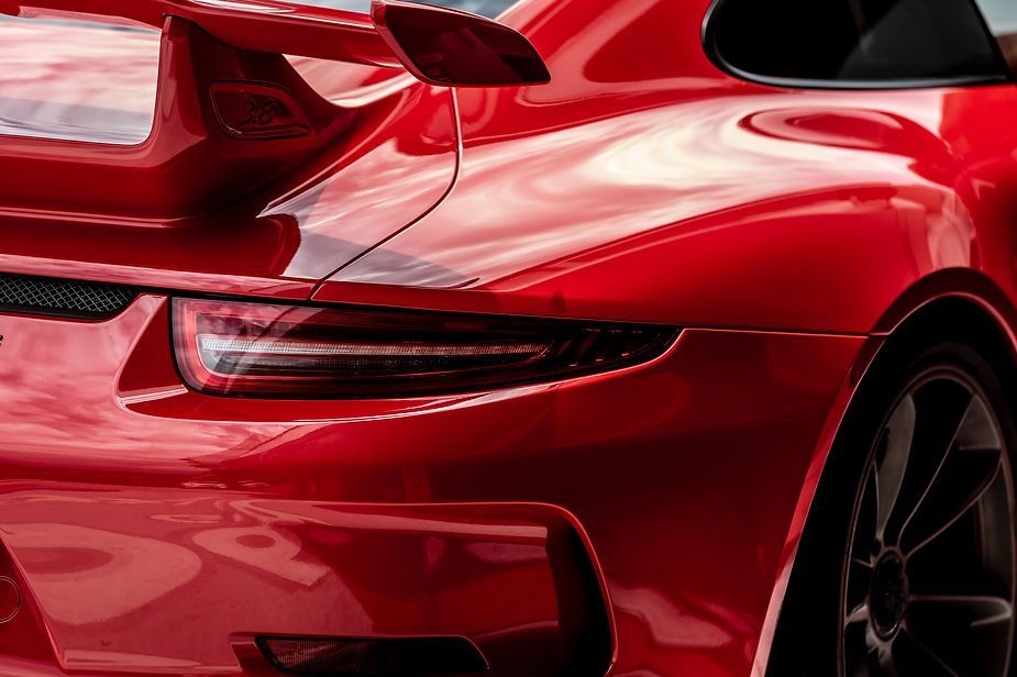 A close up of the back of a red sports car with a spoiler.