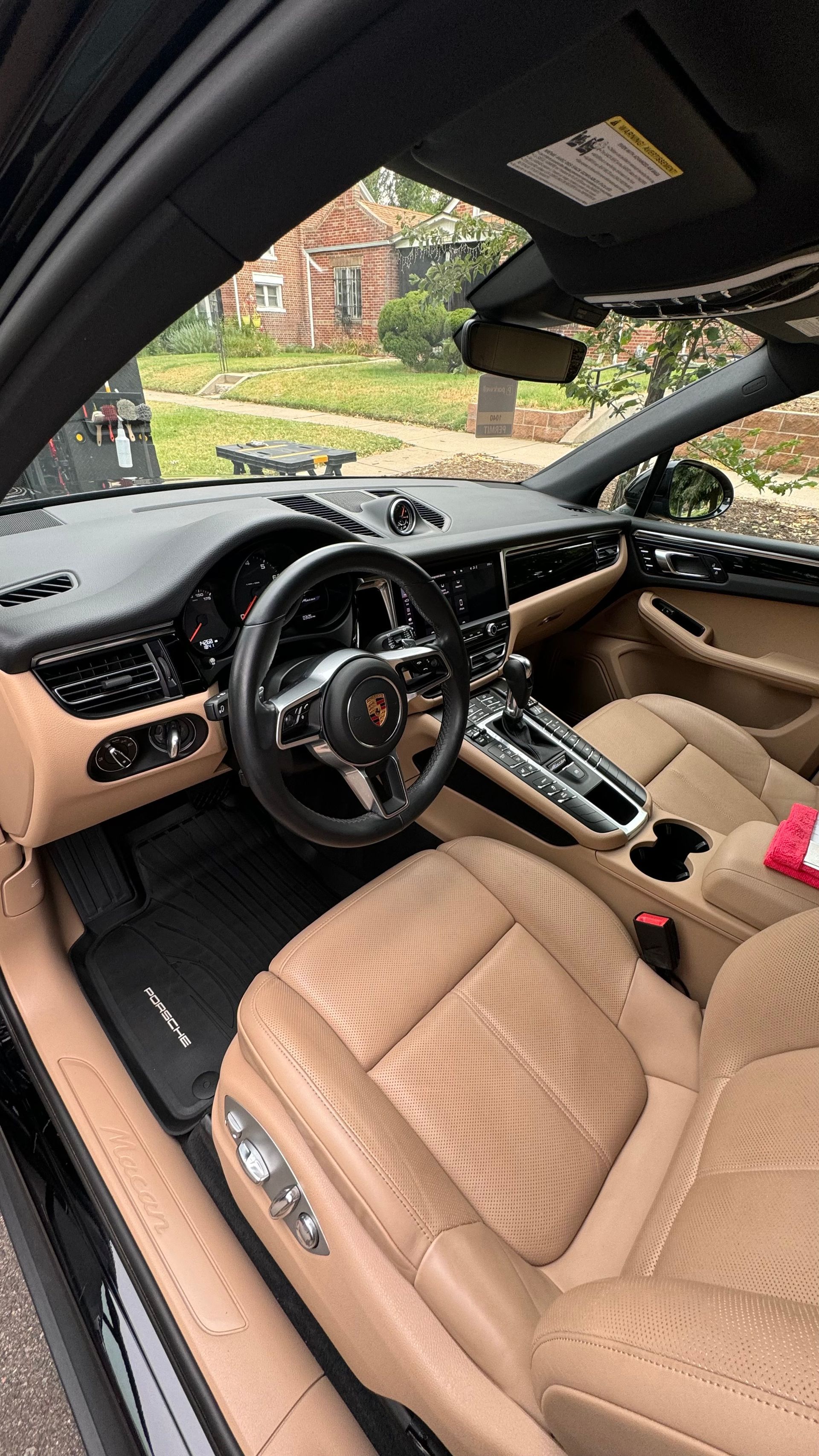 The interior of a porsche macan turbo is shown with the door open.