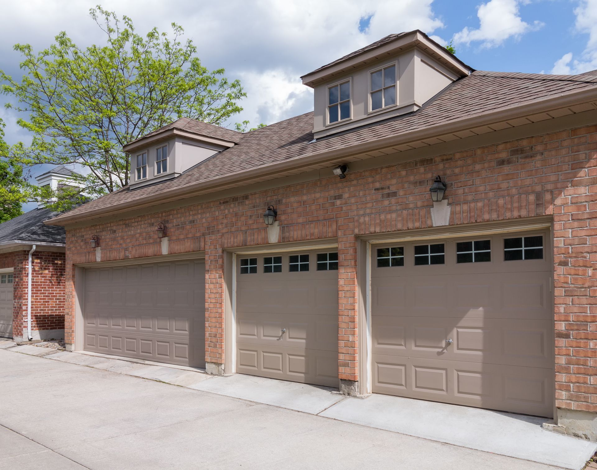Modern home with garage door replacement featuring three new garage doors