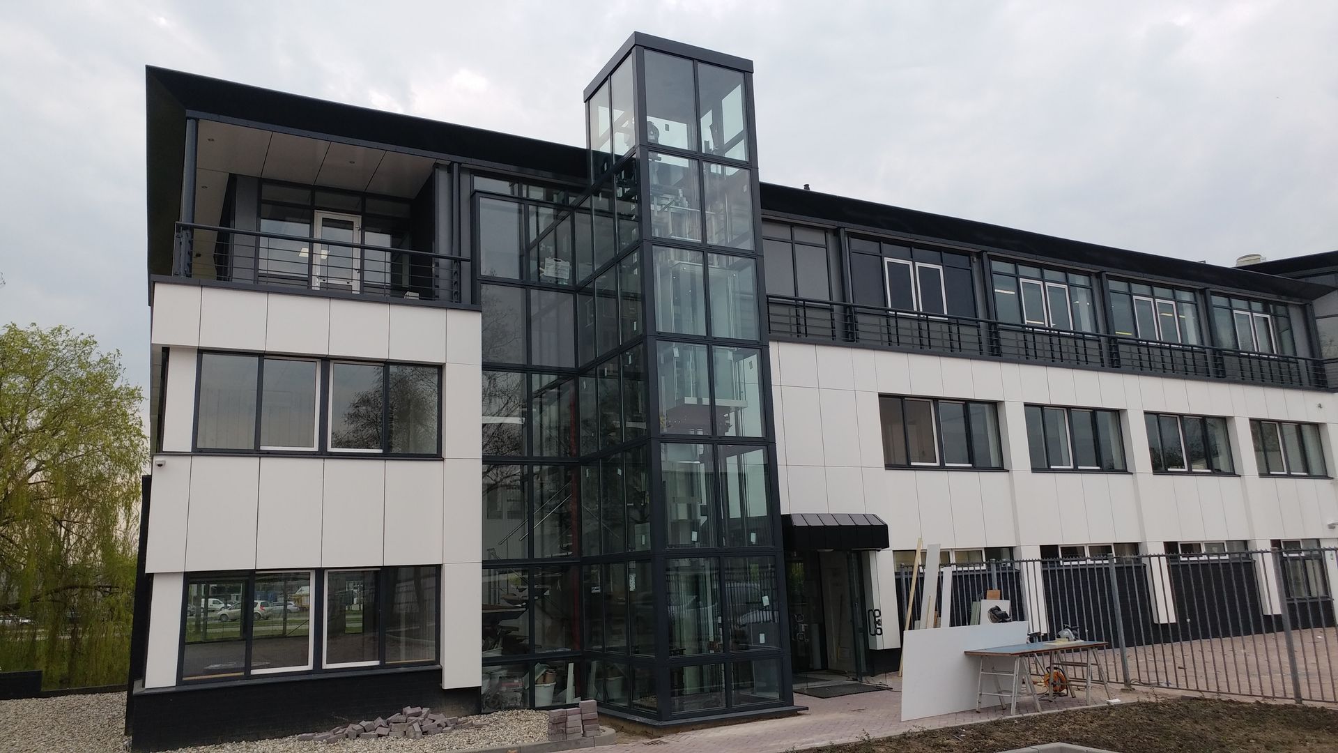 Modern white and black building with a glass elevator.