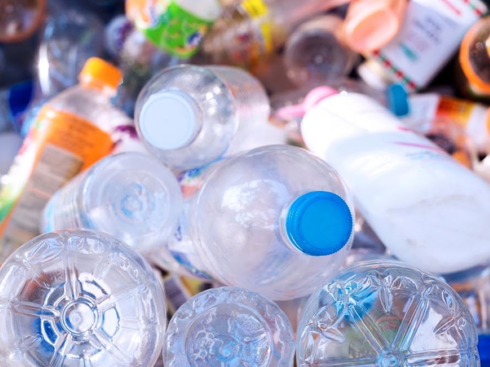 A Pile of Plastic Bottles With Blue Caps Are Sitting on Top of Each Other — The Territory Can Man In Winnelie, NT