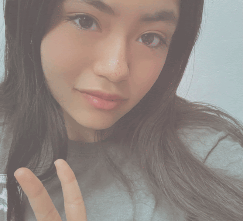 A close up of a woman giving a peace sign