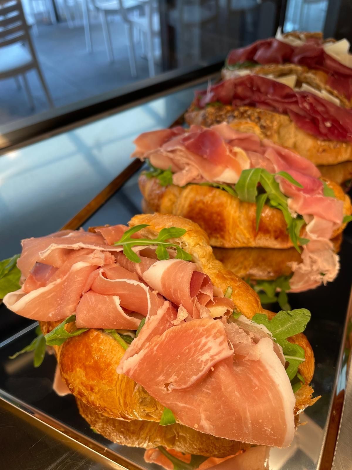 Un vassoio di panini con sopra prosciutto e lattuga