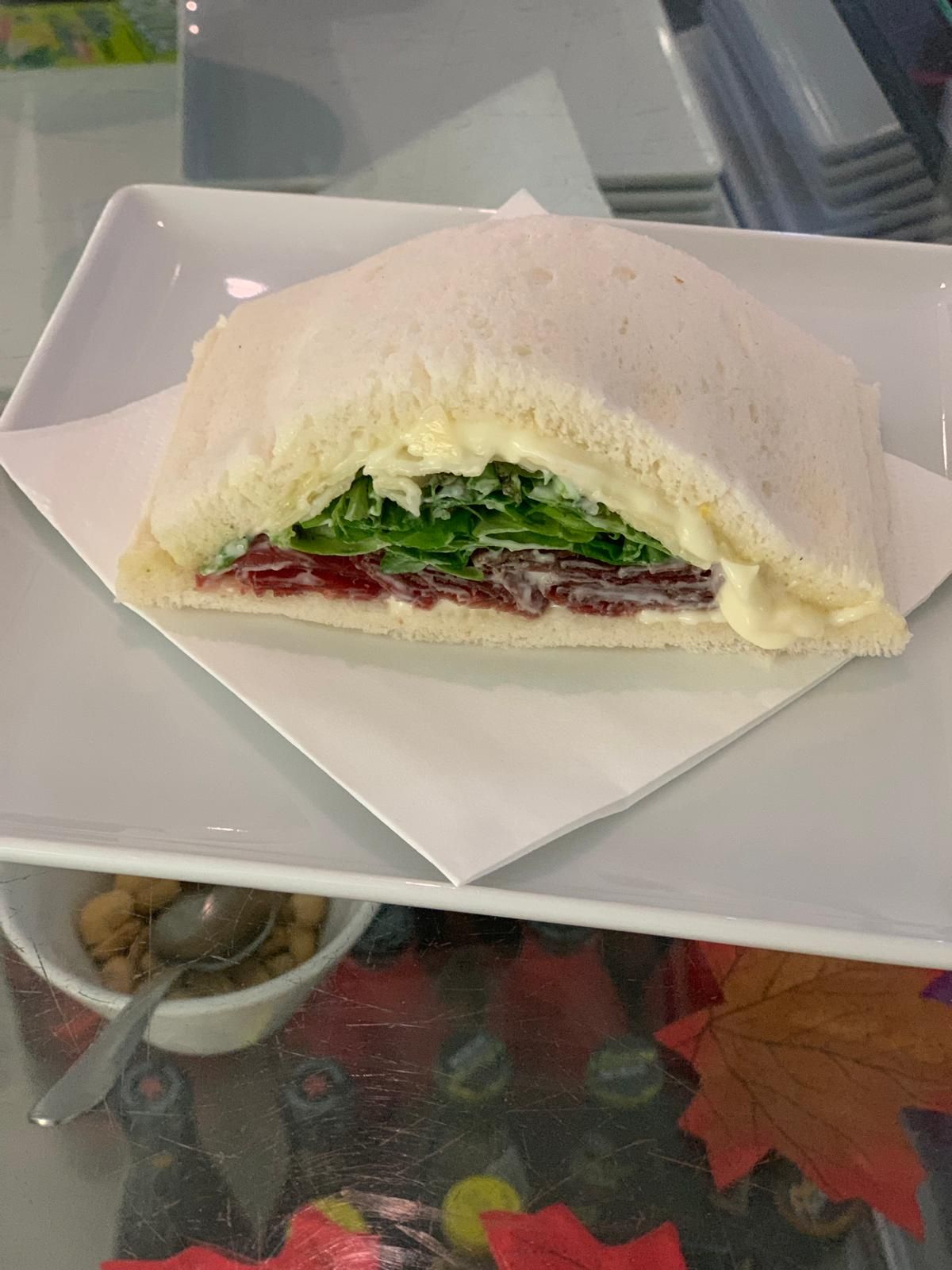 Un panino è seduto su un piatto bianco su un tavolo.