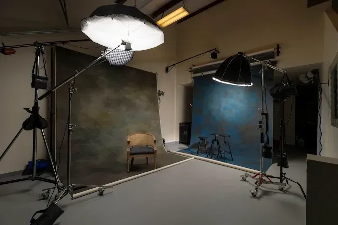 Photography studio with lighting stands, backdrops, and a seamless floor setup