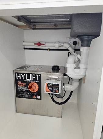 A stainless steel box with the word hylift on it is sitting under a sink.
