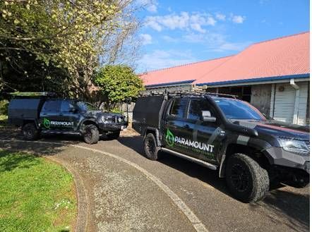 Two trucks are parked in front of a house.