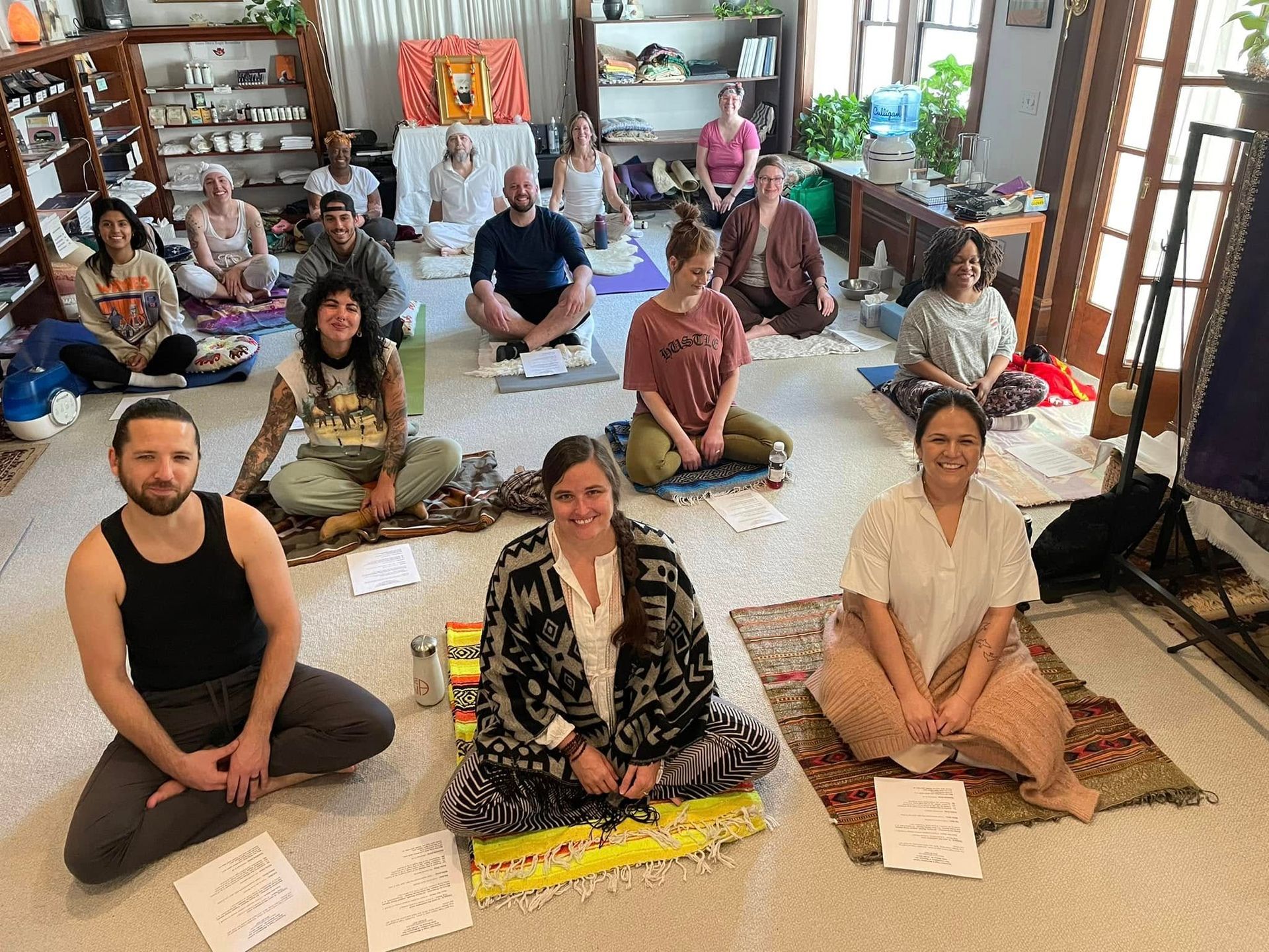 A group of people are sitting on the floor in a room.