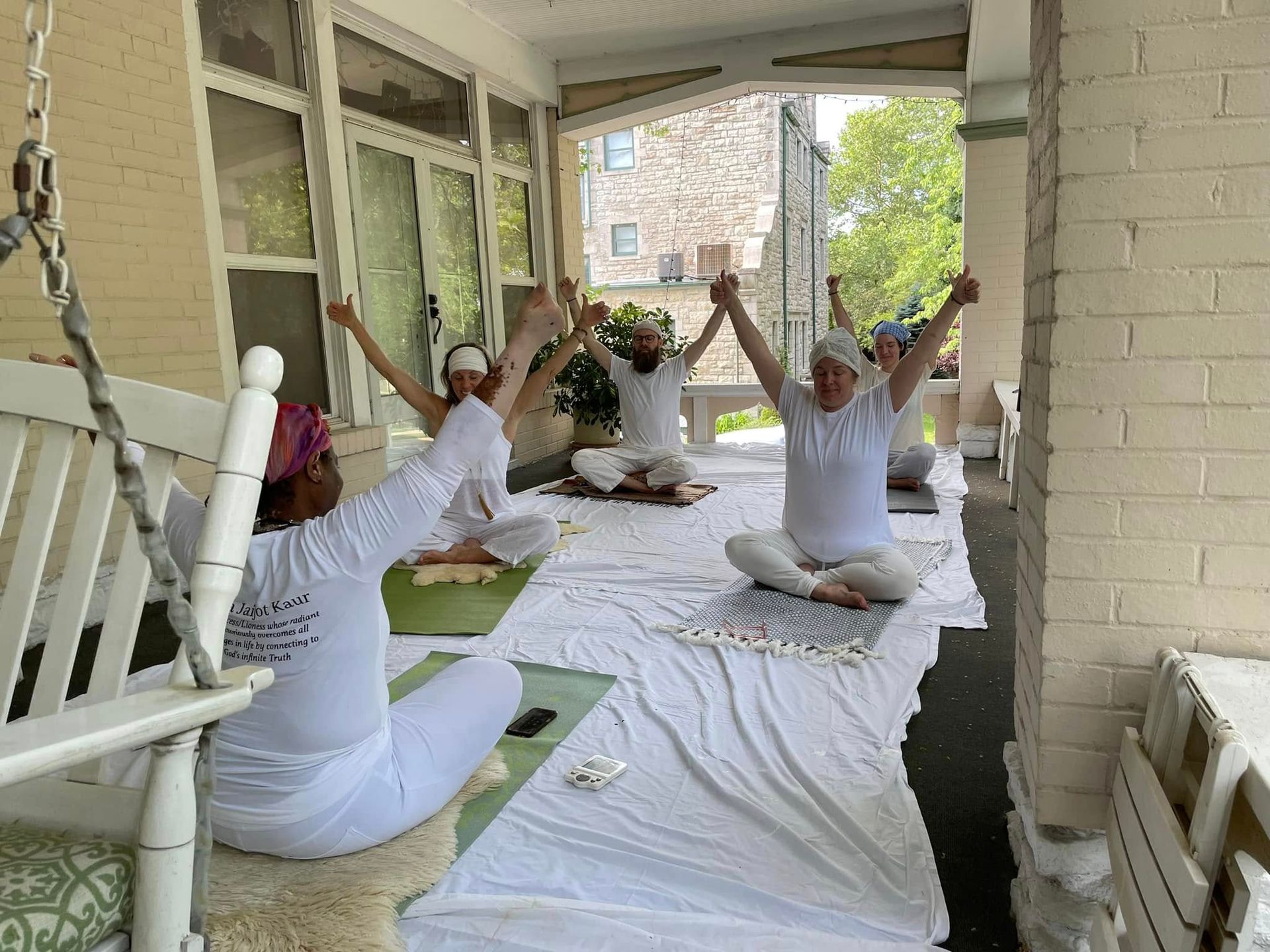 A group of people are doing yoga on a porch.