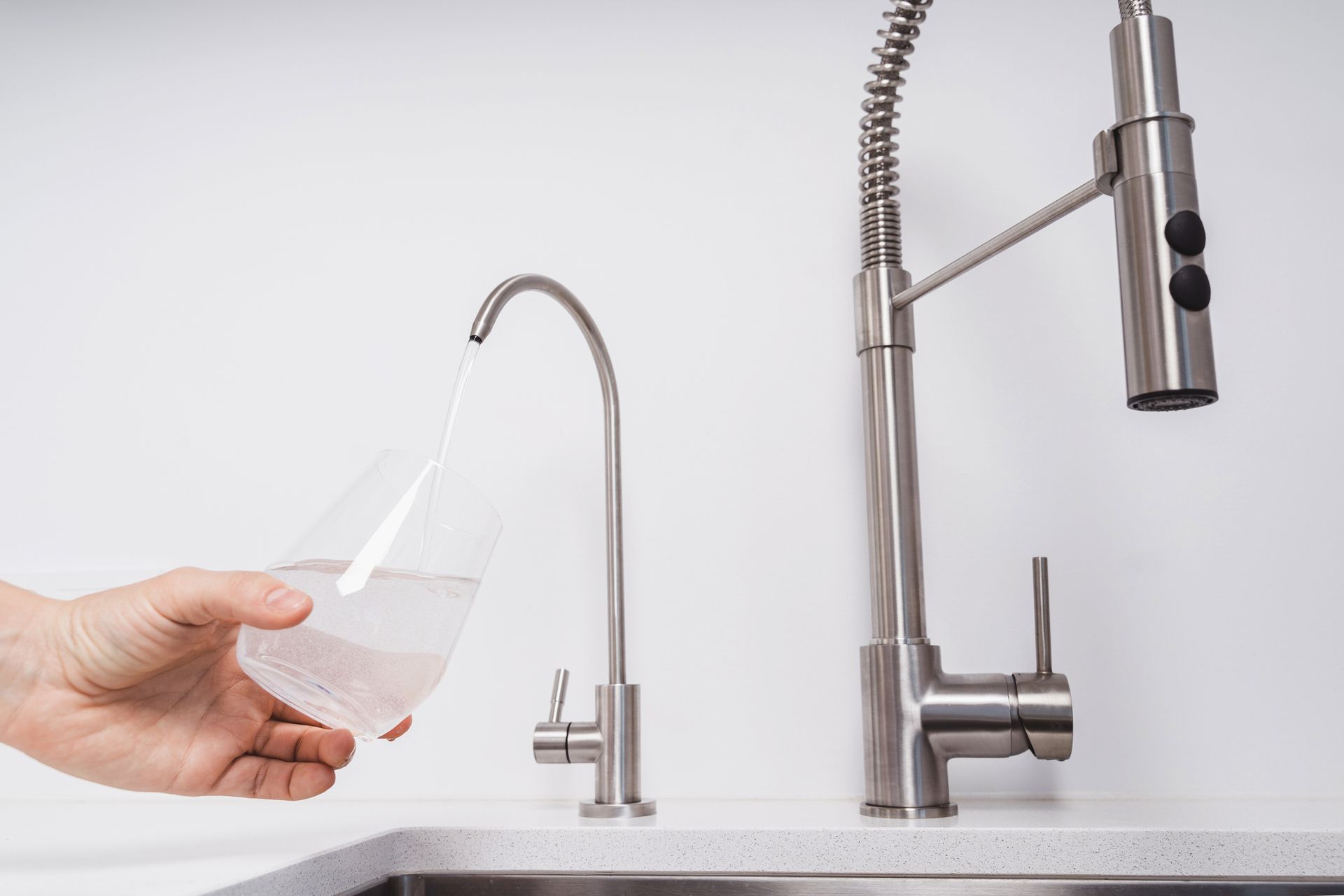 A water filter is sitting under a sink with a lot of wires coming out of it.