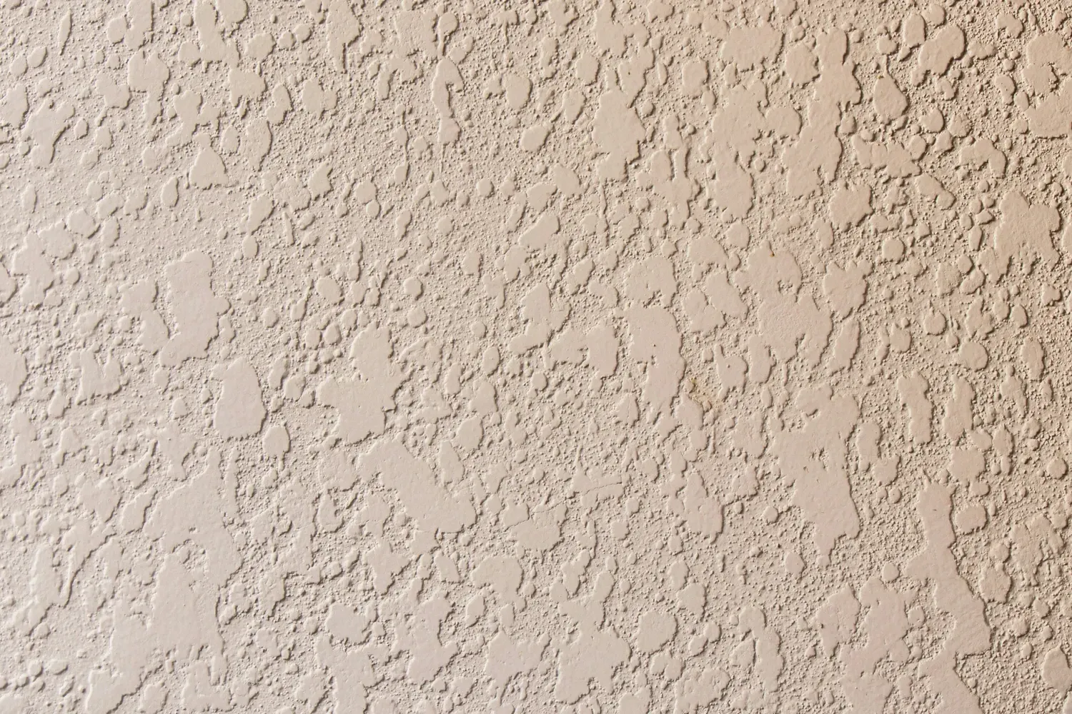 Close-up of a beige textured stucco wall