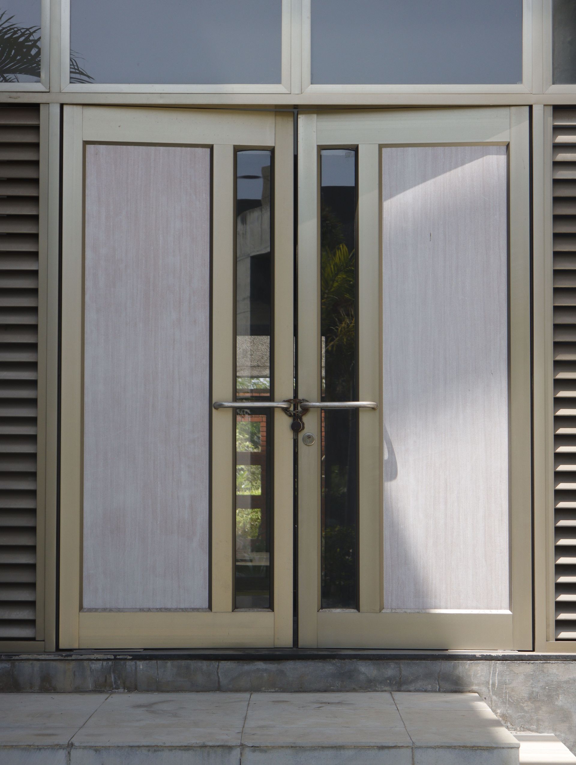 Double glass front doors with frosted panels and metal handles on a building entrance