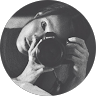 Round-framed black-and-white portrait of a person with a camera