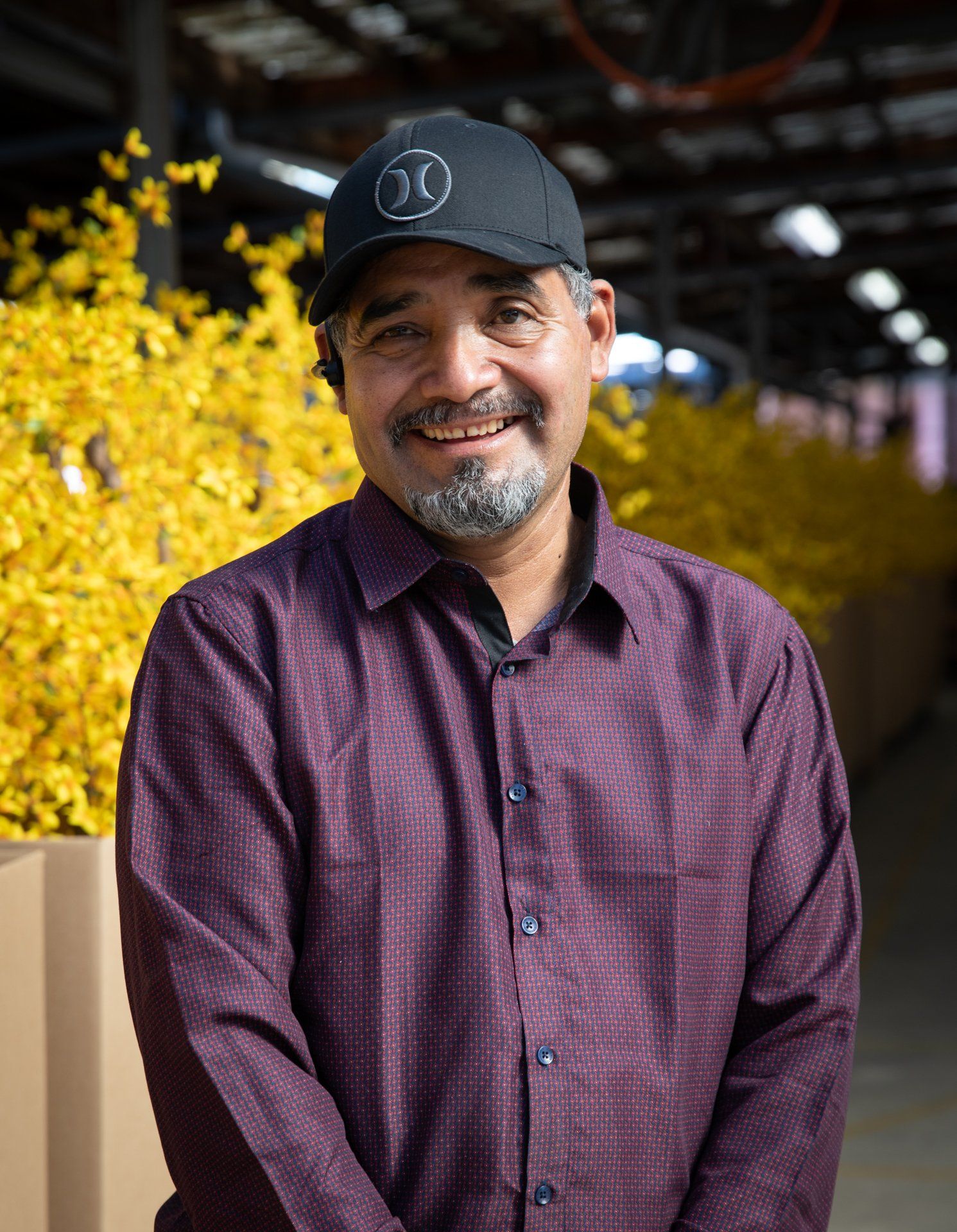 a man wearing a hat and a purple shirt is smiling for the camera .