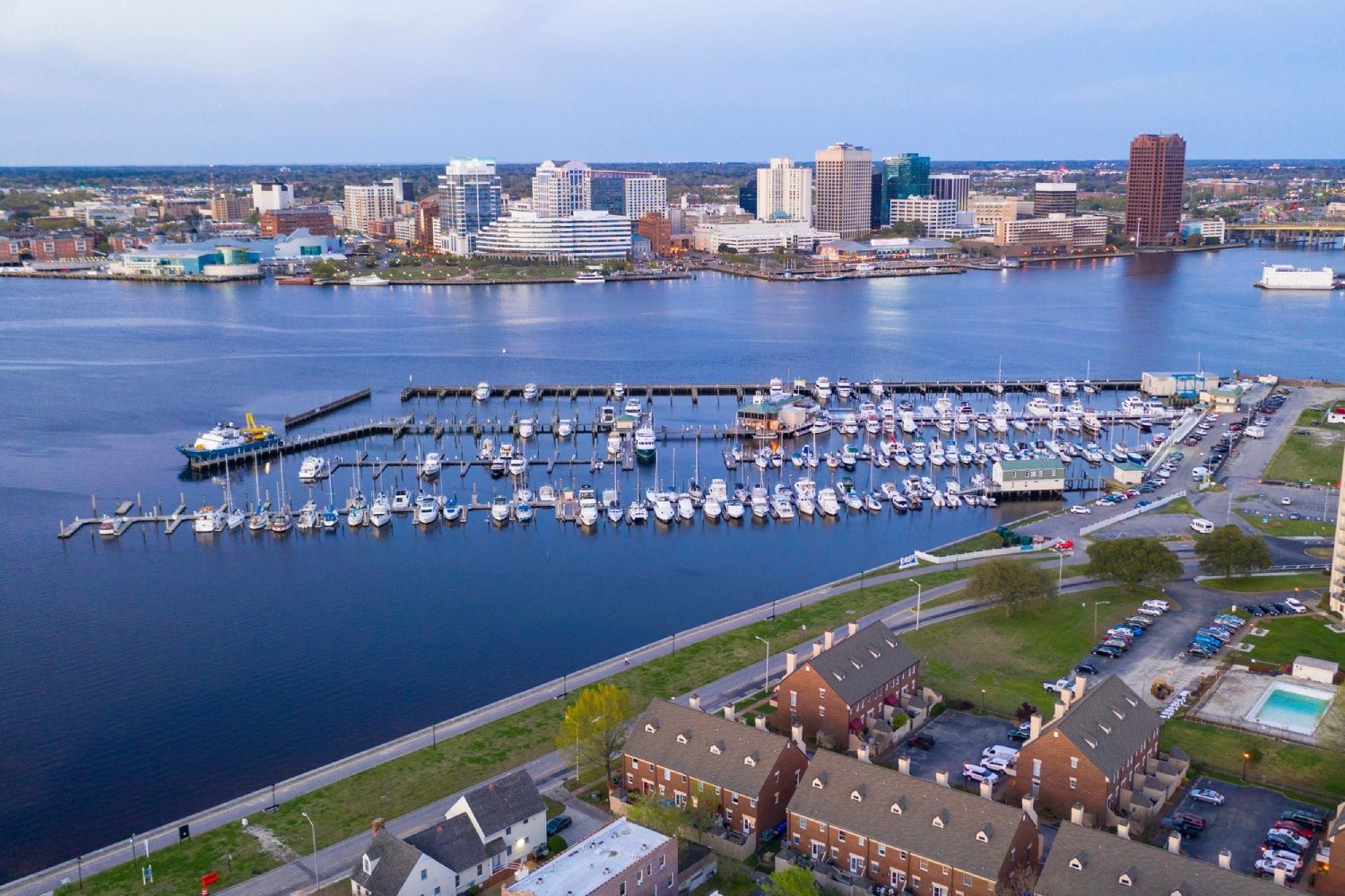 Portsmouth marina with many boats, waterfront buildings, and a city skyline across calm blue water