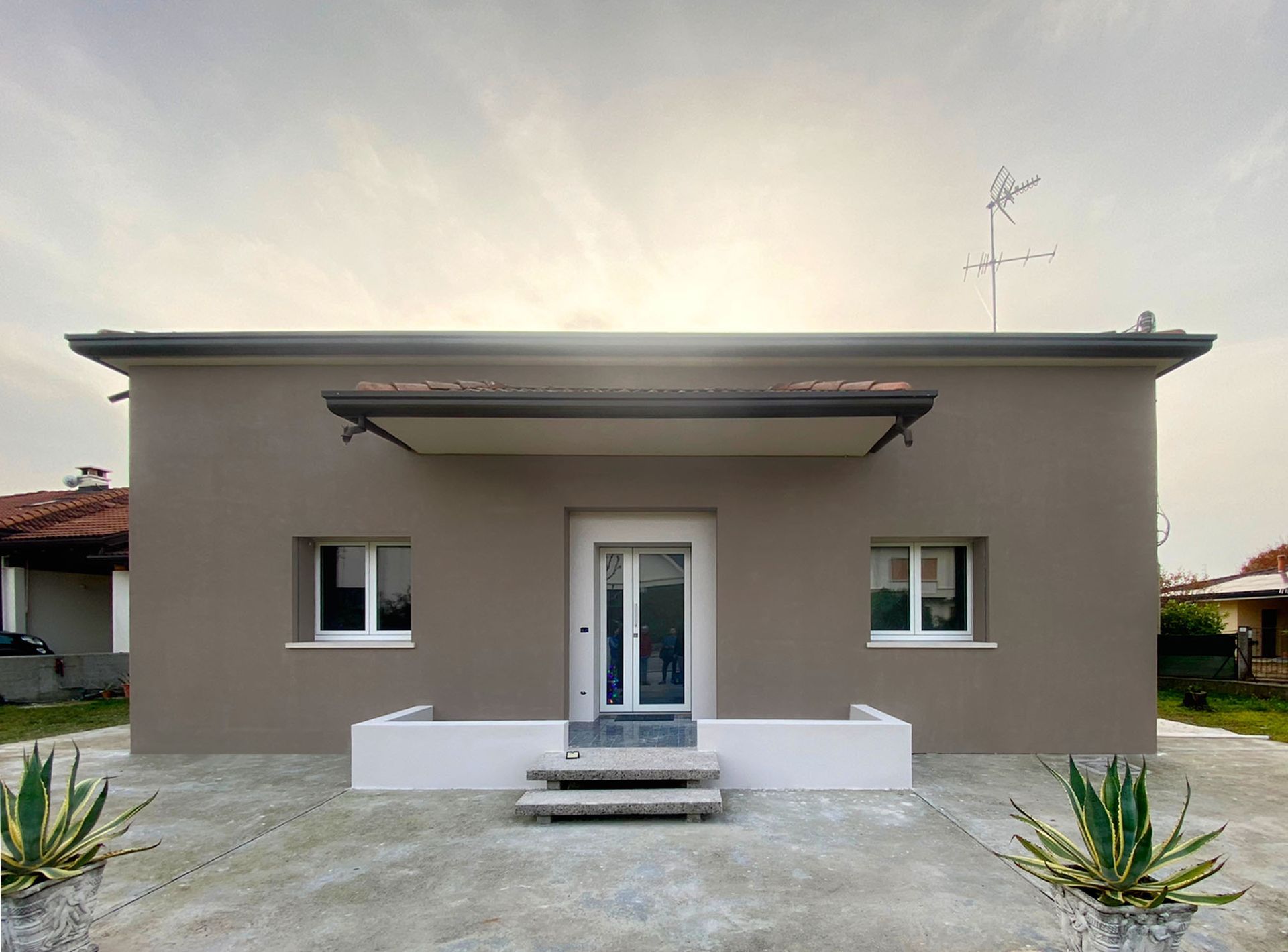 Una piccola casa con una tettoia sopra la porta d'ingresso