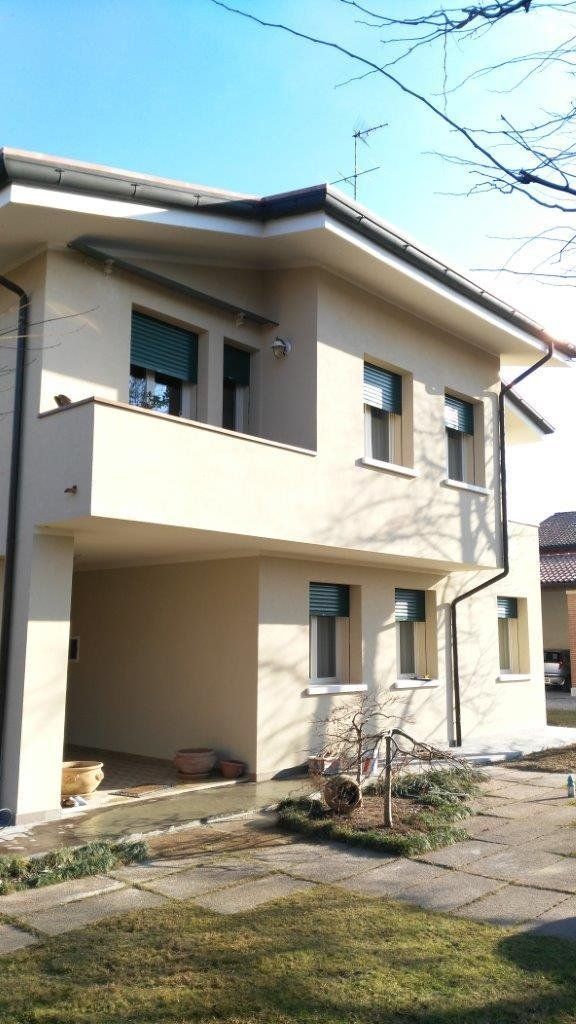 Una casa bianca con un balcone e molte finestre