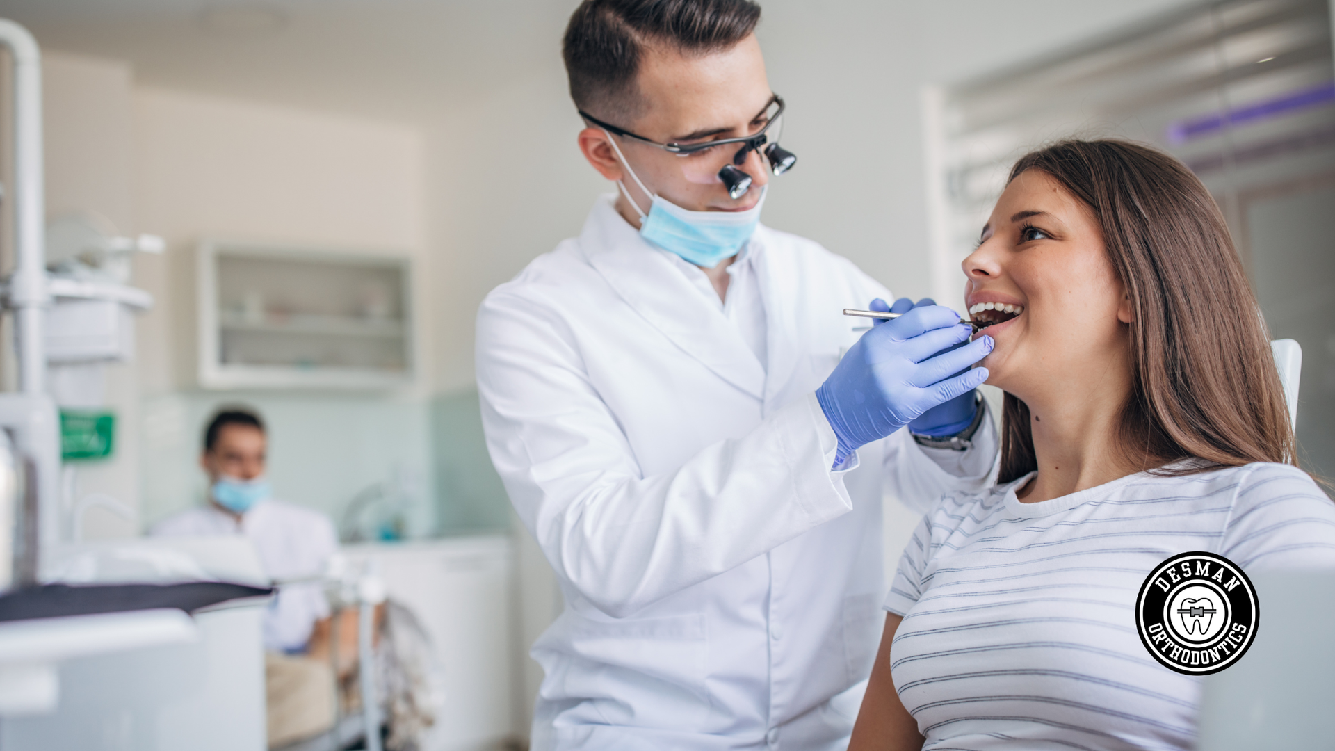 Dentist examining a smiling patient’s teeth in a bright clinic