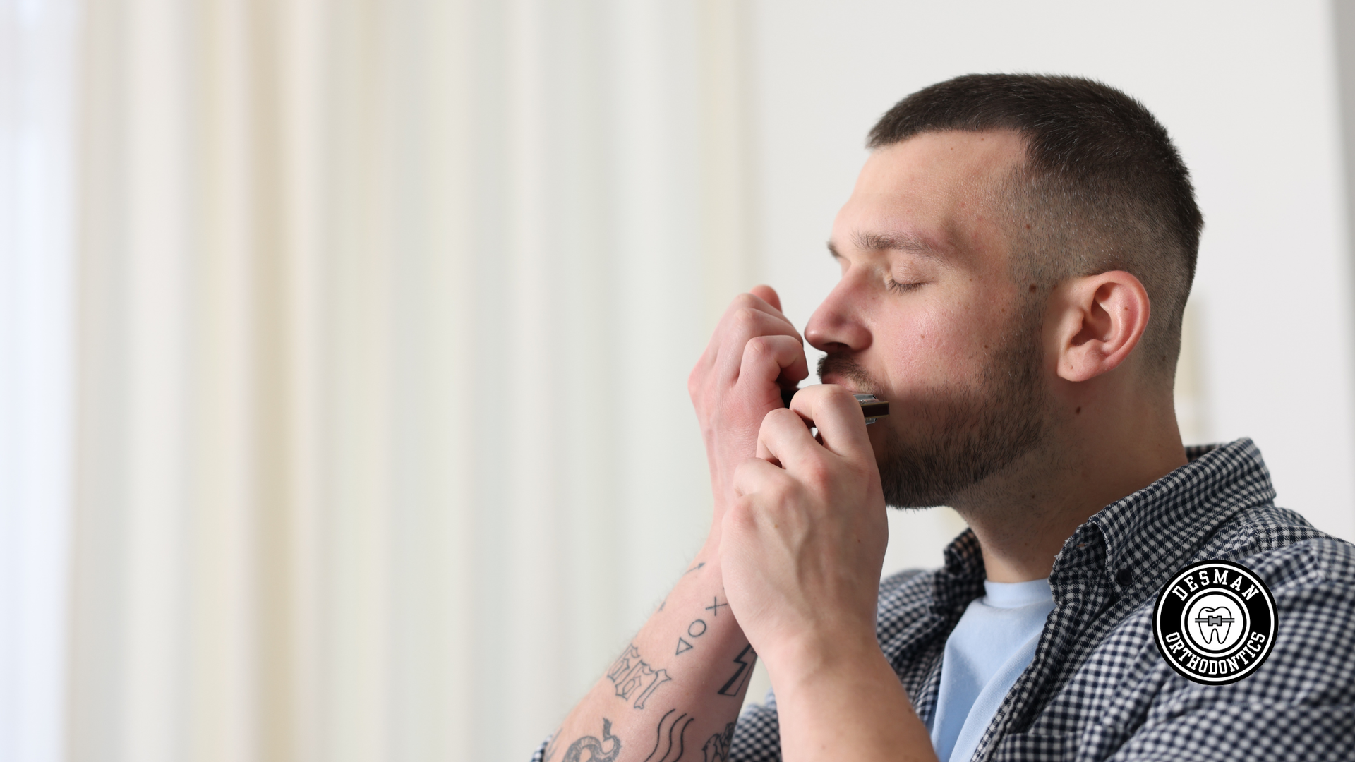 Man smoking a joint indoors, eyes closed, with a blurred background