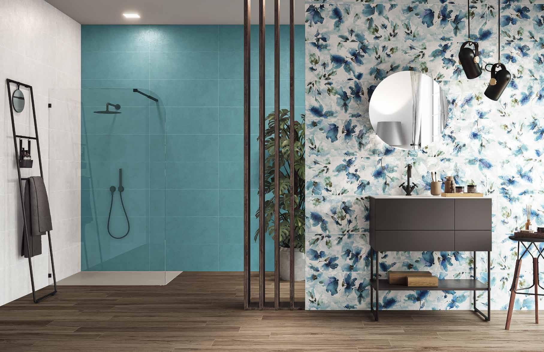 Bagno moderno con doccia blu, carta da parati floreale, mobile lavabo, specchio e pavimento in legno.