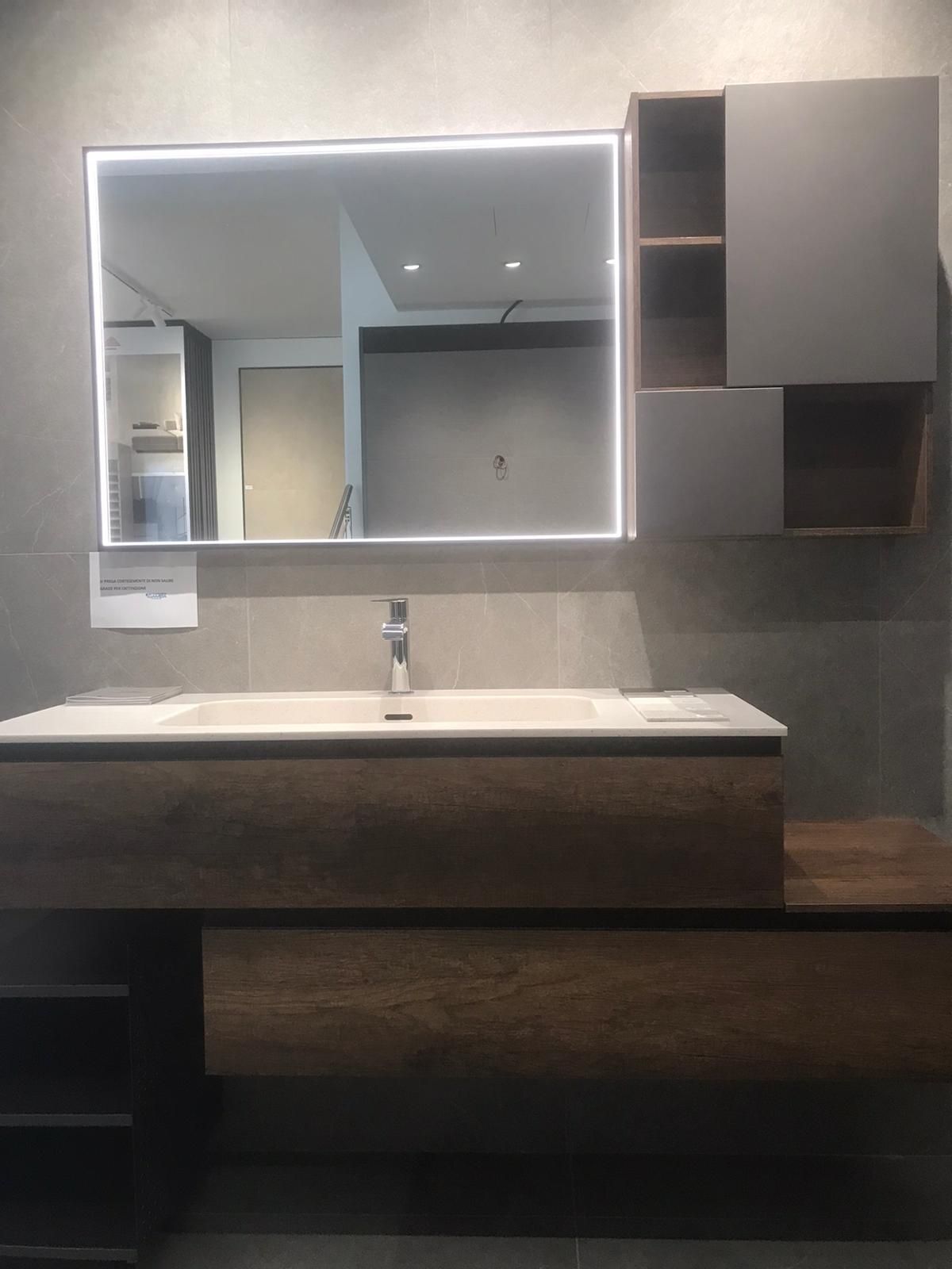 Mobile bagno moderno con ampio specchio, pareti grigie, ante in legno e lavabo bianco.
