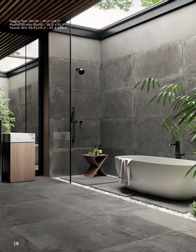 Bagno moderno in stile spa con doccia in vetro, vasca freestanding, pareti in cemento scuro e piante in vaso.