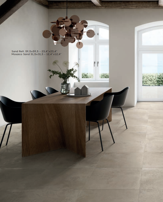 Sala da pranzo moderna con tavolo in legno, sedie nere, lampada a sospensione e ampie finestre che si affacciano sul verde.