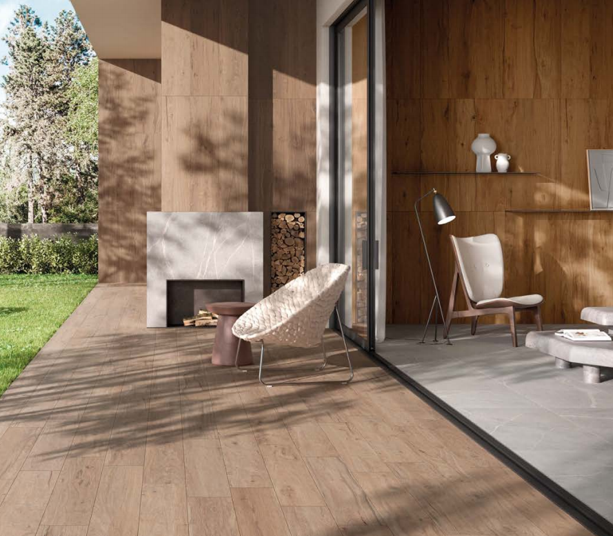 Moderno patio in legno con sdraio, camino e porte finestre che si aprono su un'accogliente zona salotto interna.