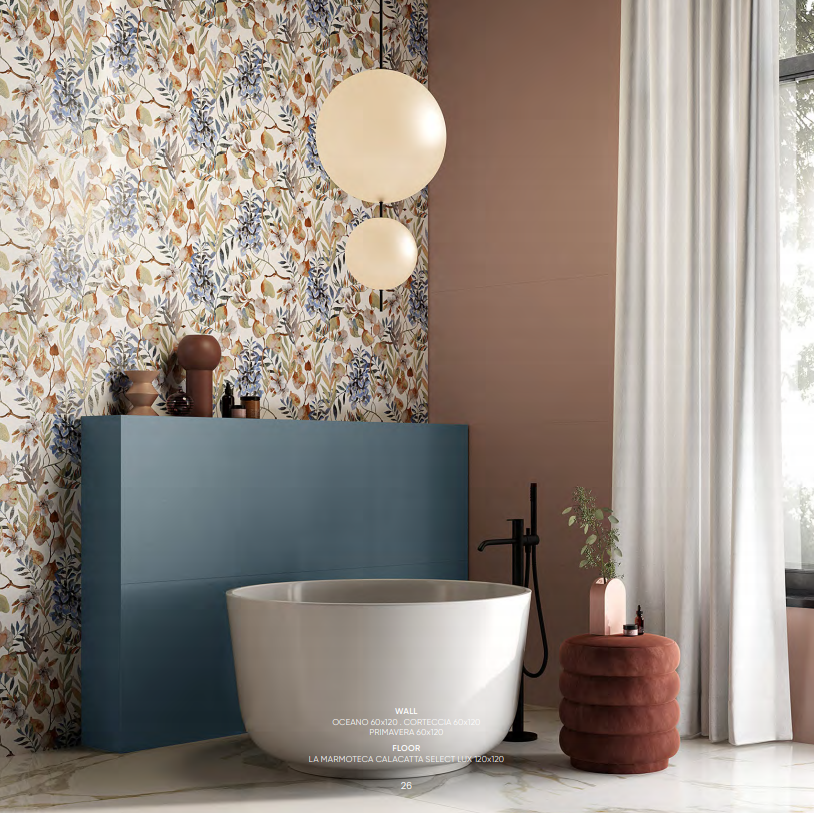 Bagno moderno con vasca freestanding, mobile lavabo blu, carta da parati floreale e lampade a sospensione a forma di globo.