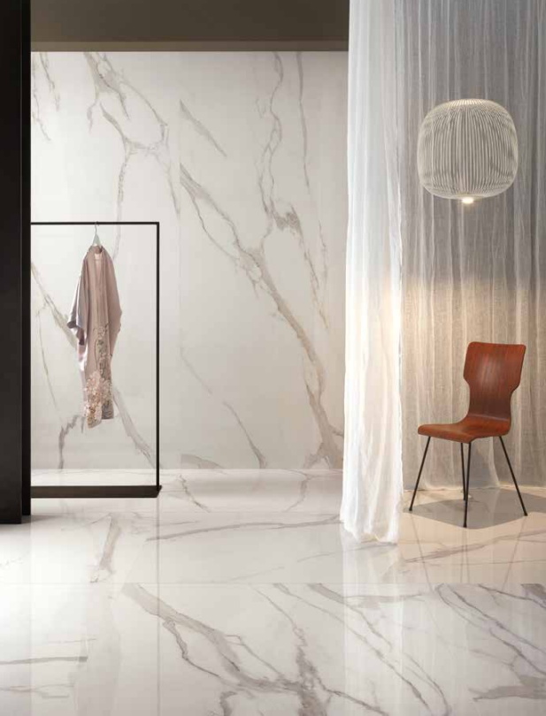 Interno moderno e minimalista con pareti e pavimento in marmo bianco, tenda trasparente e sedia rossa.