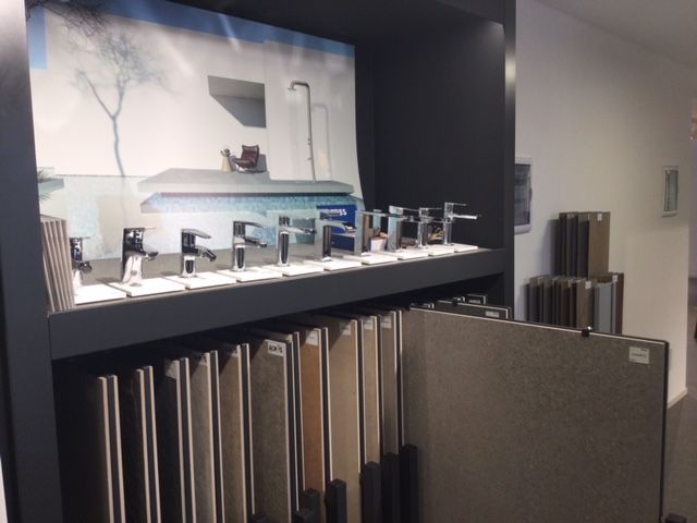 Showroom per bagni con file di porte e accessori per doccia in esposizione.