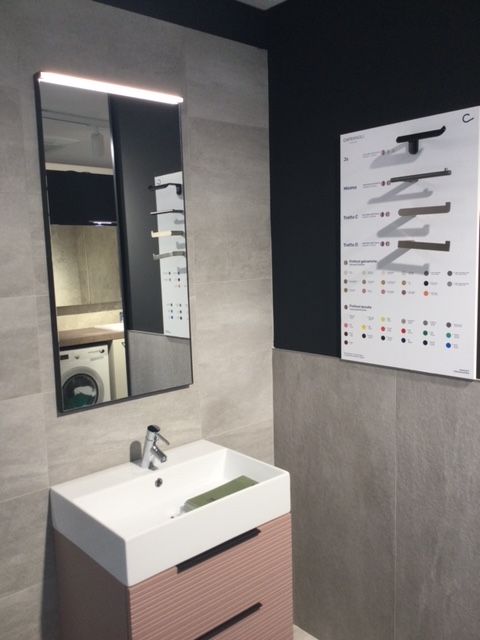 Lavabo moderno con specchio, dispenser di sapone e poster informativo sull'accessibilità a parete.