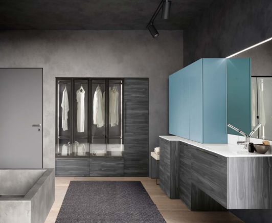 Bagno moderno con pareti grigie, mobile lavabo blu, grande specchio con armadietto e finestra con tende trasparenti.