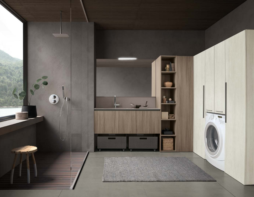 Lavanderia moderna e minimalista con lavatrice, mensole in legno, pareti grigie e sedile sotto la finestra.