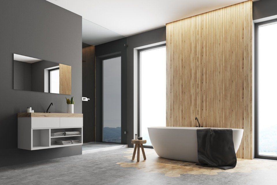 Bagno moderno con vasca freestanding, parete con inserti in legno e mobile lavabo con specchio in un ambiente minimalista.