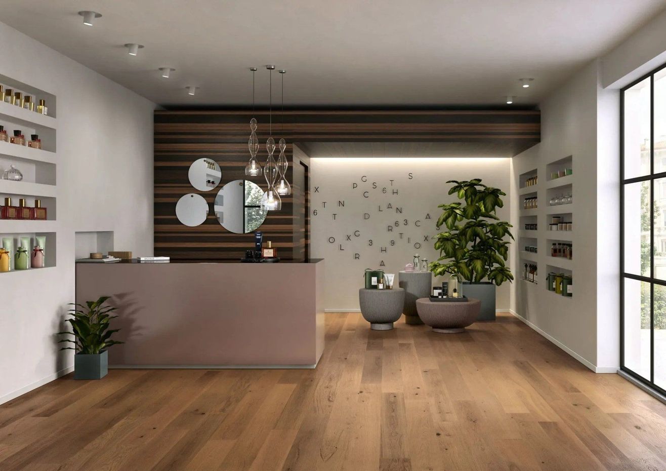 Soggiorno moderno e minimalista con pavimento in legno, pareti bianche, piante e un piccolo bancone reception.