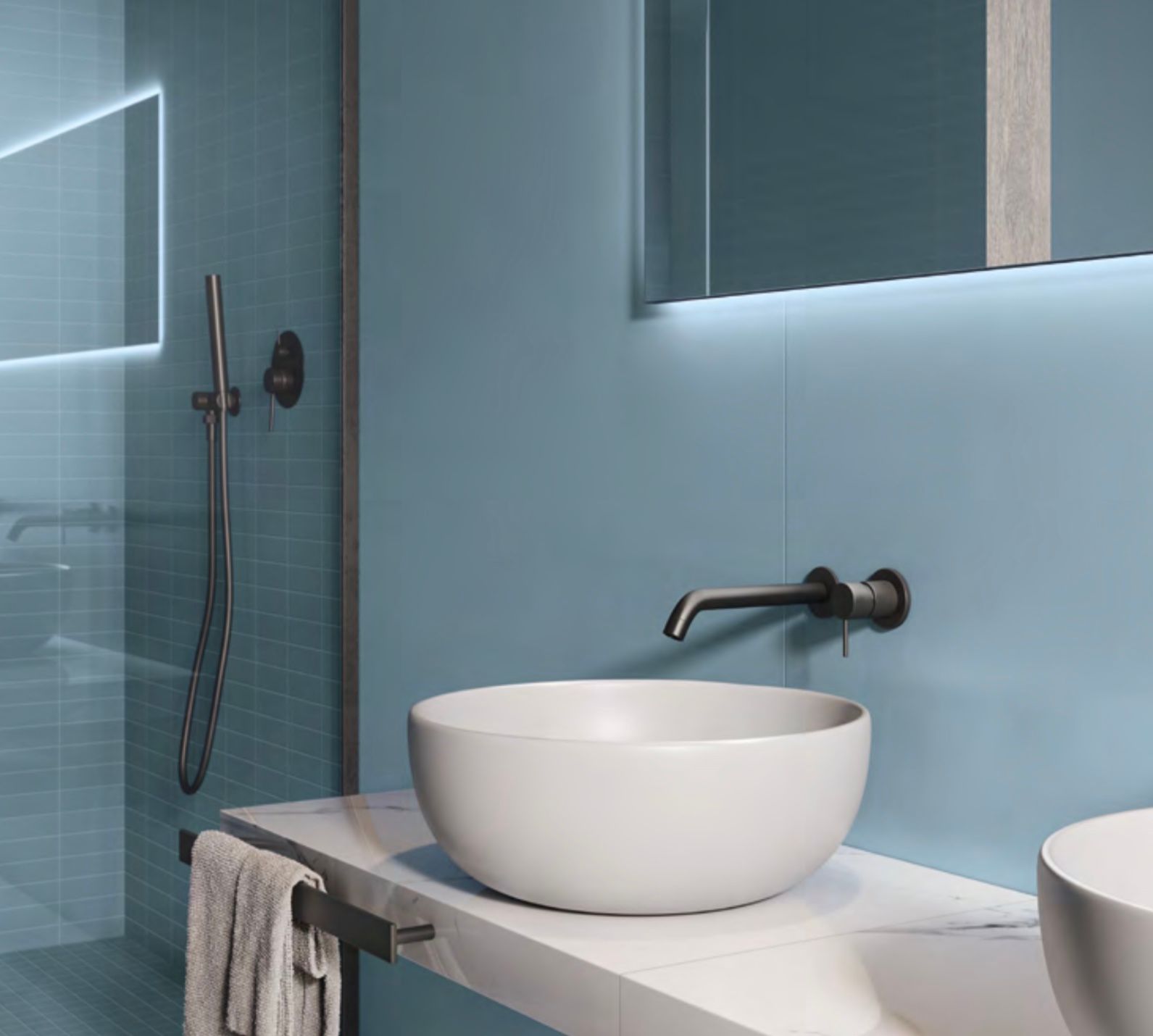 Lavabo da bagno moderno con vasca a ciotola bianca, rubinetto a parete, pareti blu e box doccia in vetro.