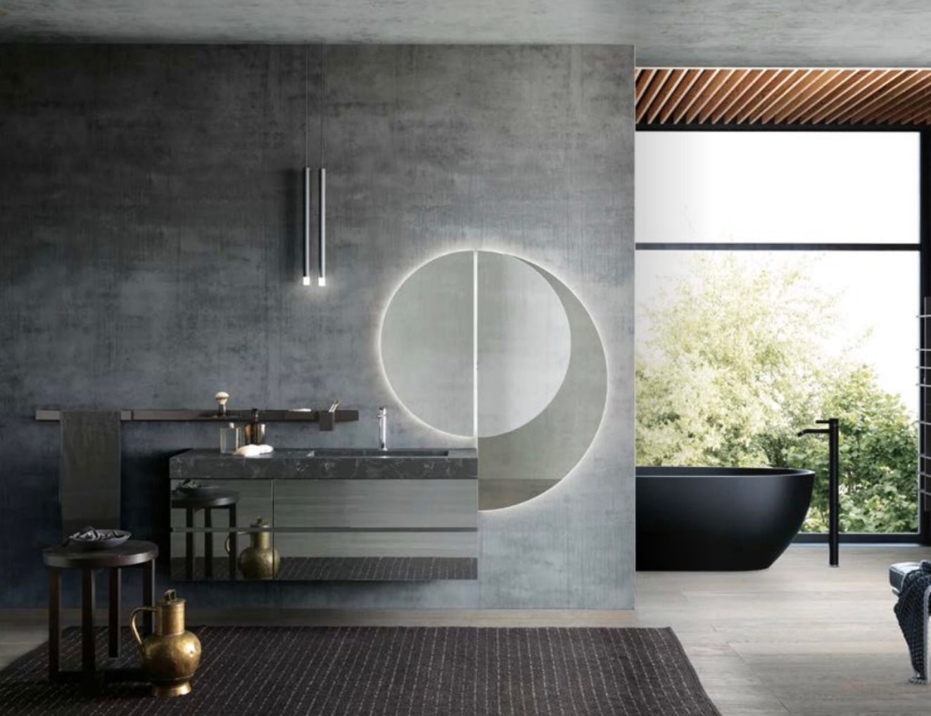 Bagno moderno grigio con specchio circolare, doppio lavabo, vasca e ampia finestra panoramica.
