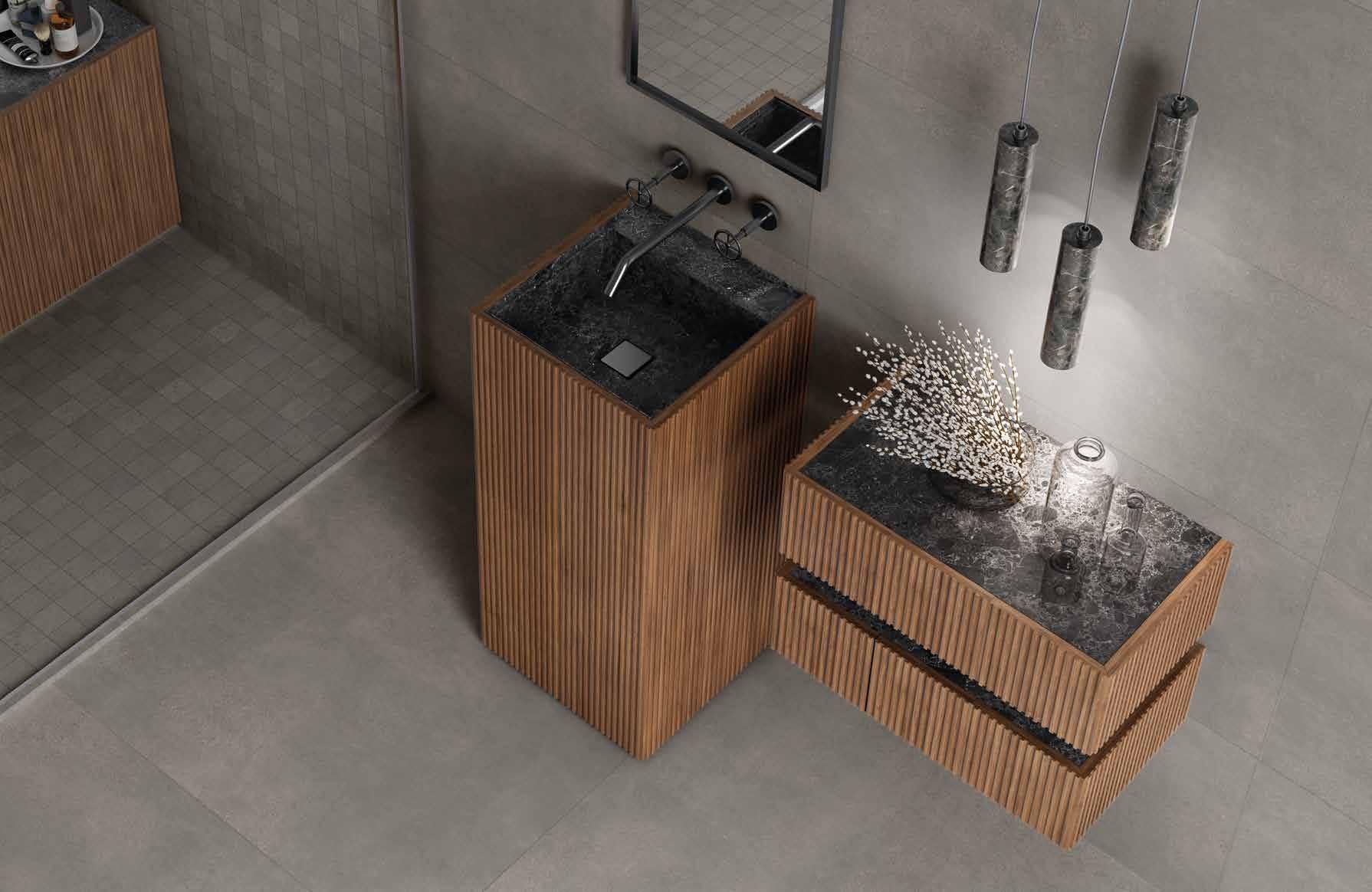 Moderno patio esterno con due bracieri in legno su un pavimento in cemento grigio, uno dei quali con fiamme e fumo visibili.