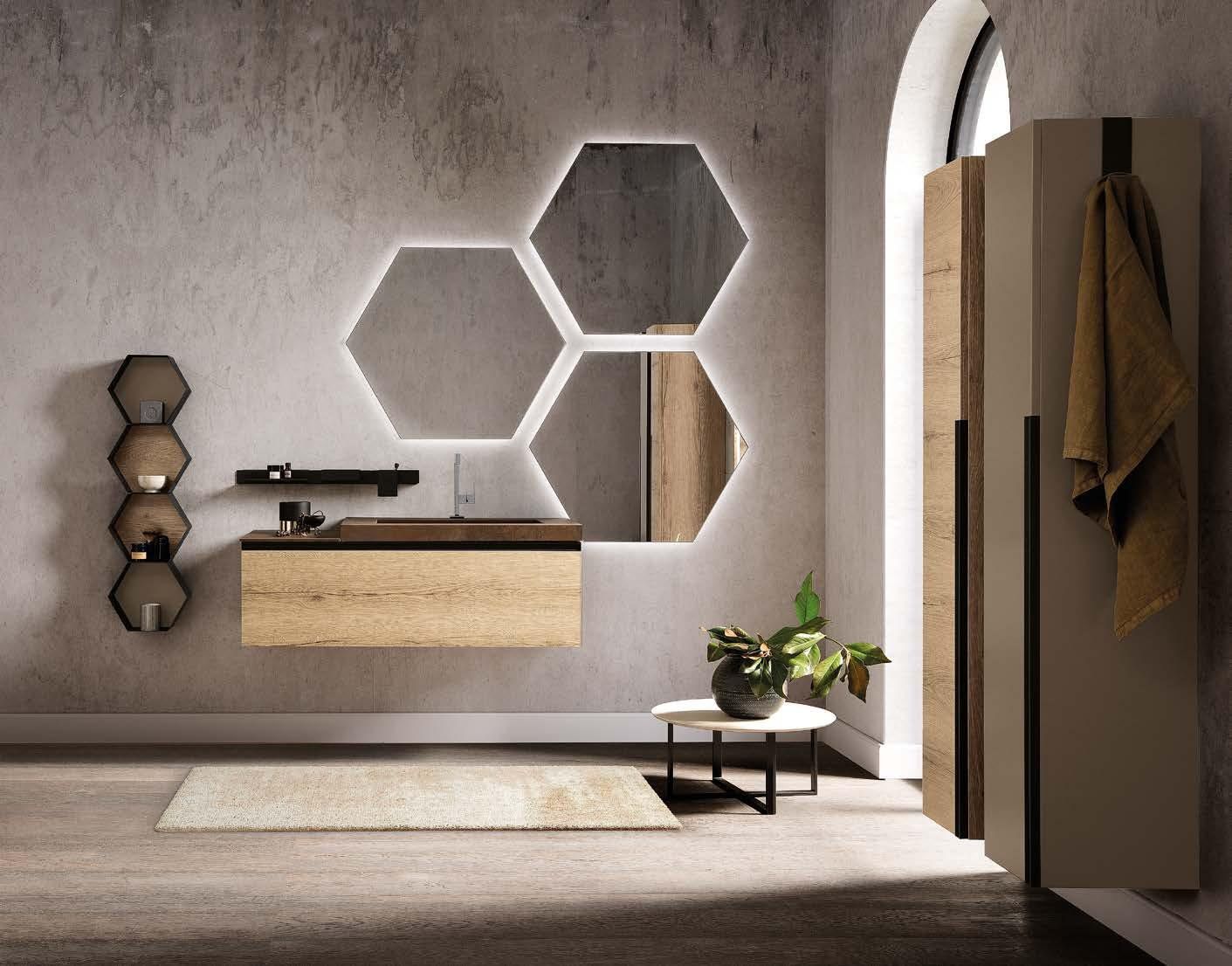 Bagno moderno con mobile lavabo sospeso in legno, specchi esagonali, mensola a muro e portasciugamani accanto alla finestra.