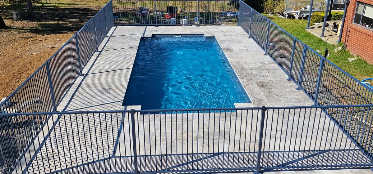 Rectangular Swimming Pool Enclosed by a Metal Fence — Newcorp Pools In Moore Creek, NSW