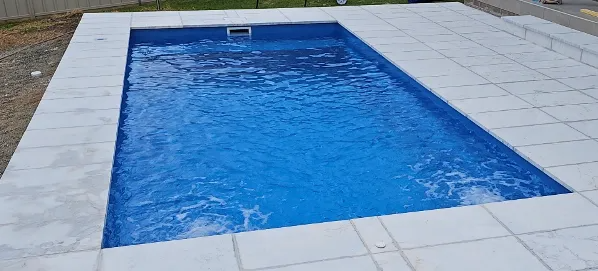 Rectangular Swimming Pool Filled With Blue Water Surrounded by White Tiles — Newcorp Pools In Moore Creek, NSW