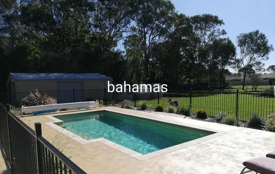 Swimming Pool With Concrete Patio, Black Fence, Shed, and Green Lawn — Newcorp Pools In Moore Creek, NSW