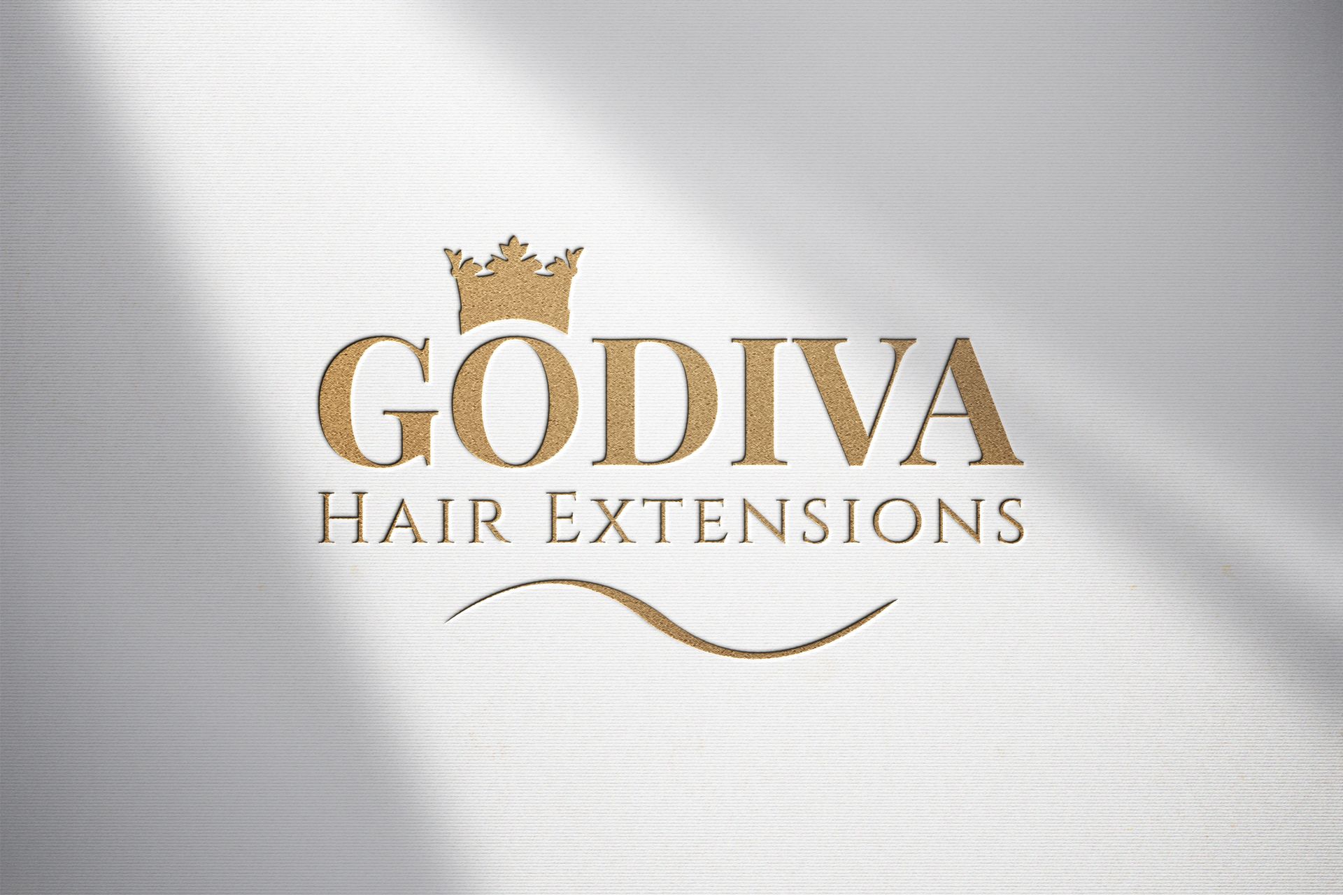 A logo for godiva hair extensions with a crown on it