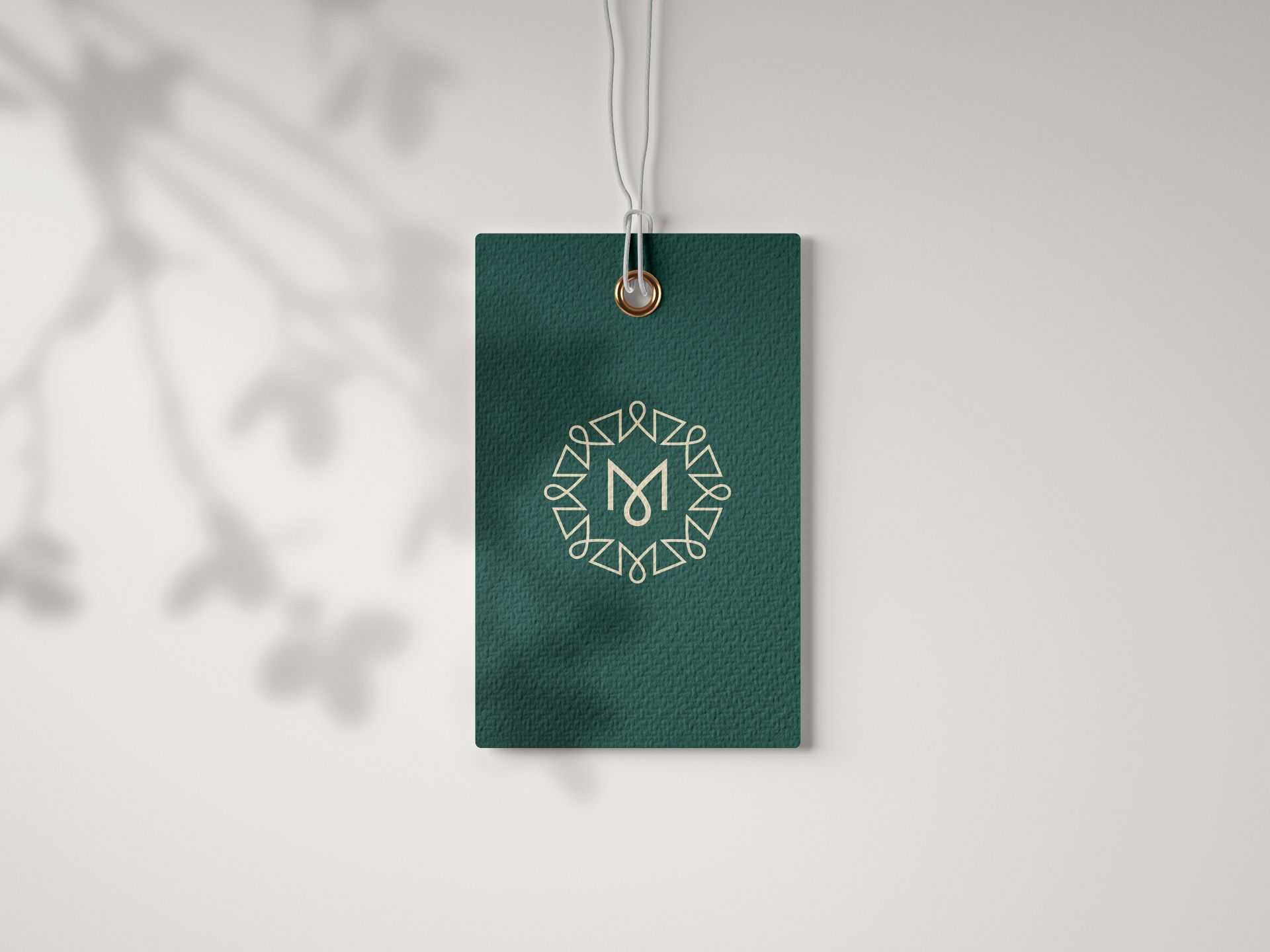 A green tag with a logo on it is hanging on a string.