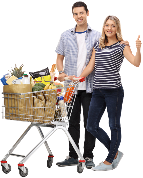 A man and a woman are standing next to a shopping cart filled with groceries.
