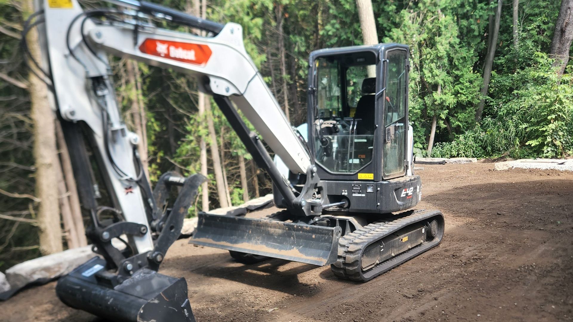 A bobcat excavator is sitting on top of a dirt field.